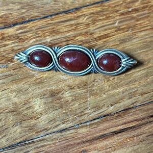broach with burgundy stone and gold accents